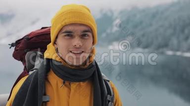 穿着<strong>冬装</strong>的年轻迷人男子的肖像。 穿着黄色<strong>冬装</strong>的徒步旅行者看着摄像机